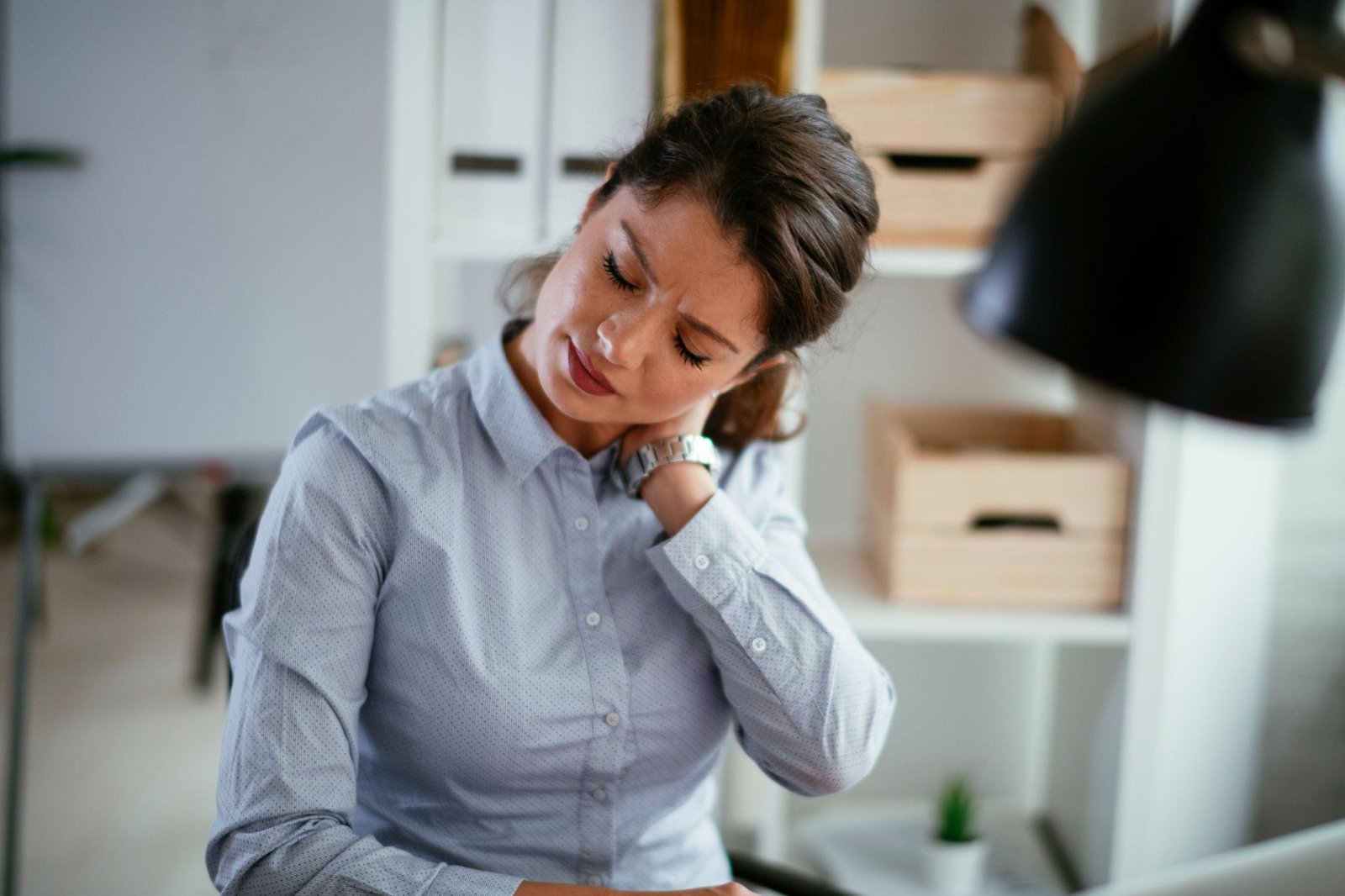 Woman experiencing Hashimoto's Thyroiditis symptoms with thyroid gland discomfort